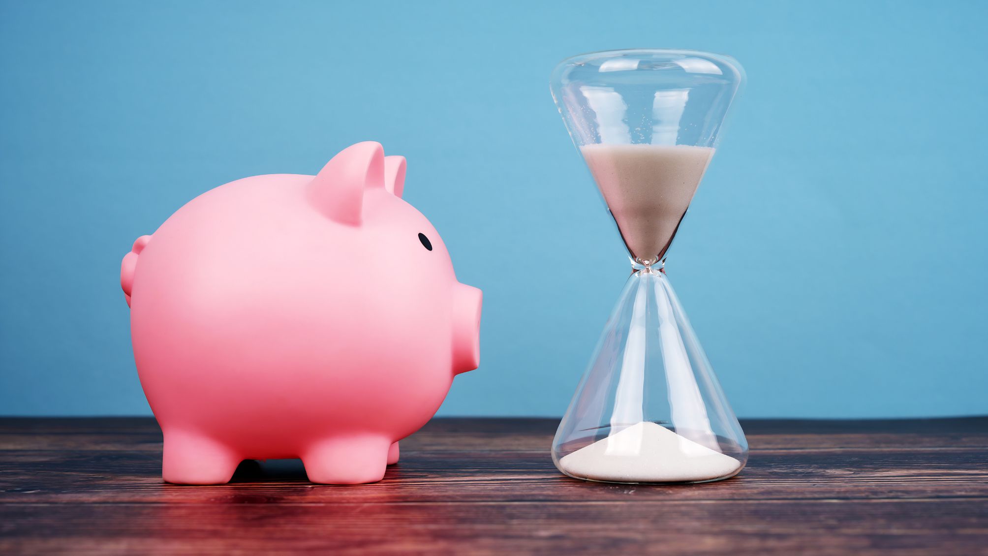 A piggy bank staring at an hour glass