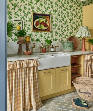 Utility room with yellow cabinets and ivy wallpaper