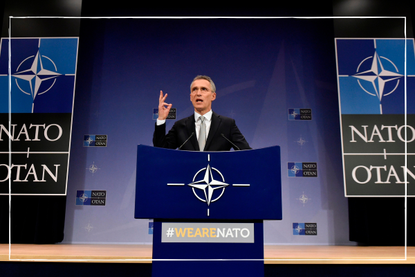 a close up of NATO president giving an address from NATO headquarters