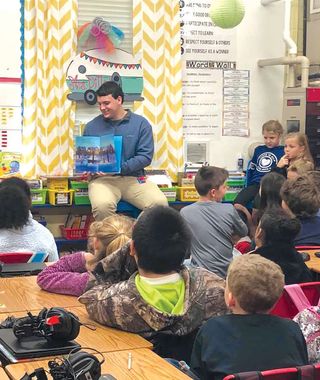A junior at Neshoba Central High School reads to fourth-grade students at Neshoba Central Elementary School.