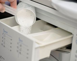 Loading powder laundry detergent into the detergent drawer on a washing machine