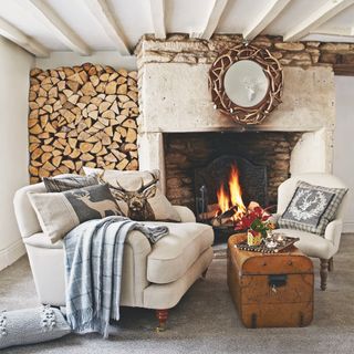traditional stone fireplace with cream armchairs in front