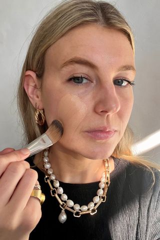 Katie applying Laura Mercier Real Flawless Weightless Perfecting Foundation with a foundation brush