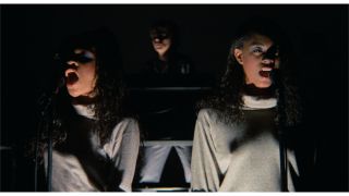 Ednah Holt, Jerry Harrison, and Lynn Mabry sing while ominously lit in Stop Making Sense.