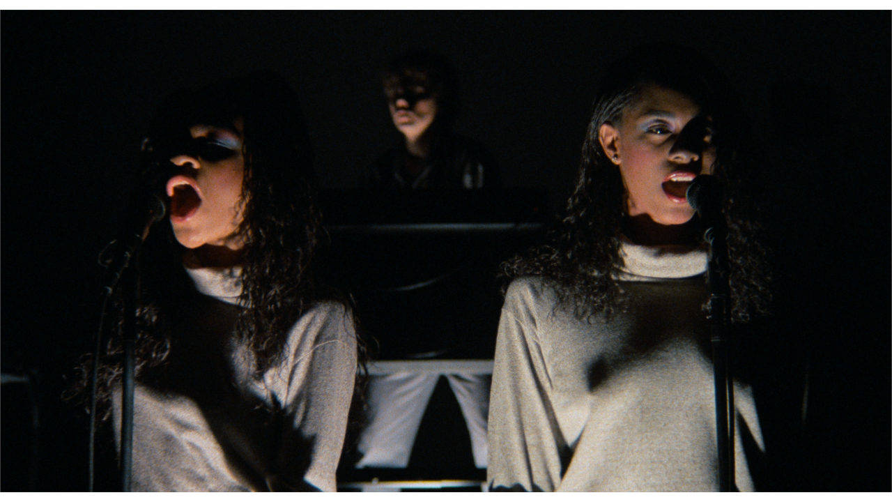 Ednah Holt, Jerry Harrison, and Lynn Mabry sing while ominously lit in Stop Making Sense.