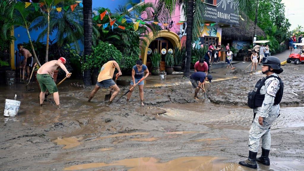 People clear the streets after Hurricane Roslyn hit Mexico.