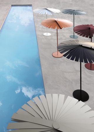 An overview of fan shaped parasols in different colours next to a long thin pool.