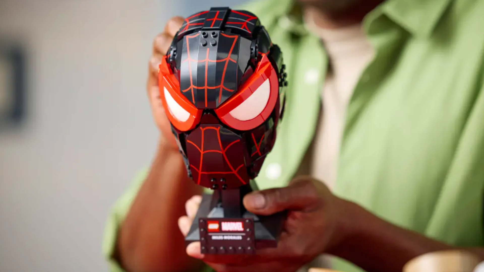 A person holds out the Lego Miles Morales' Mask kit
