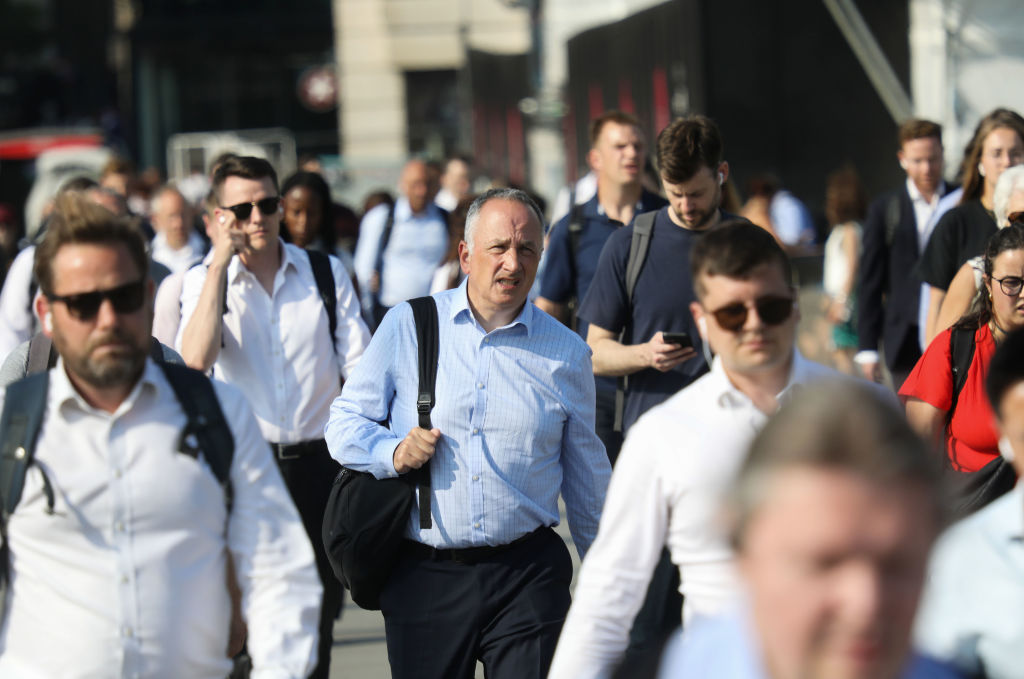 People walk across London Bridge from the City of London