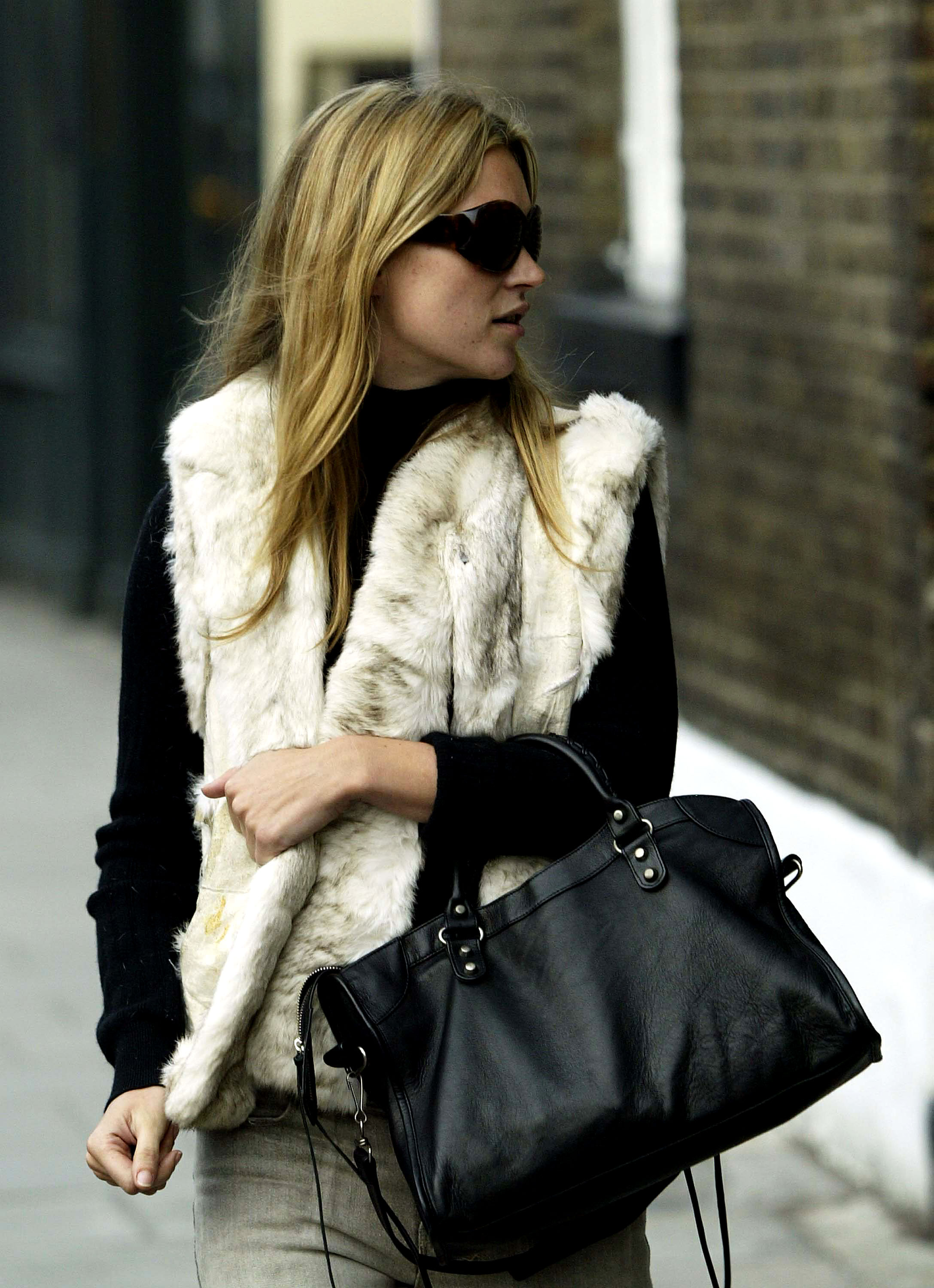 An image of Kate Moss wearing a city bag, one of the biggest 2010 fashion trends, while out in London.