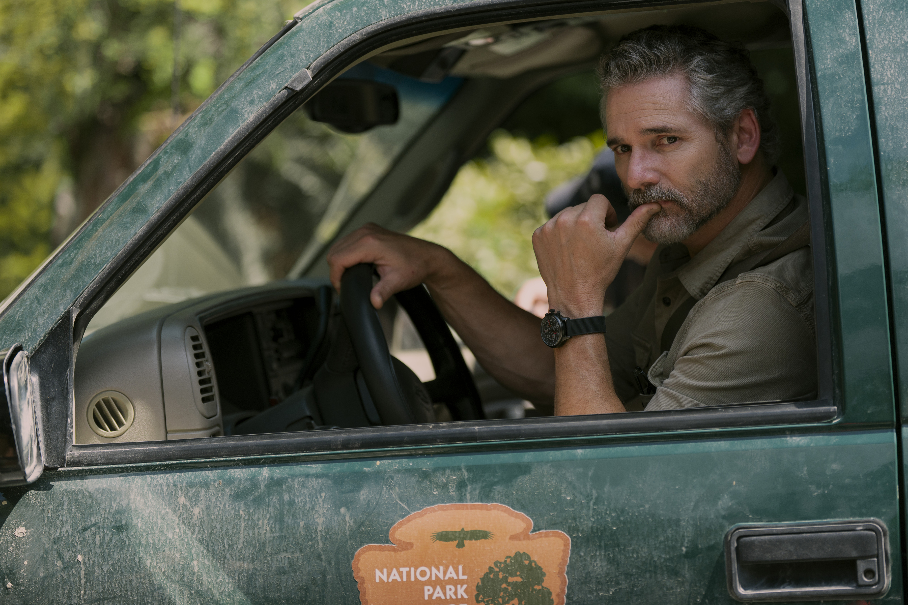 eric bana as office turner riding in a national parks service truck through the woods in the tv show untamed