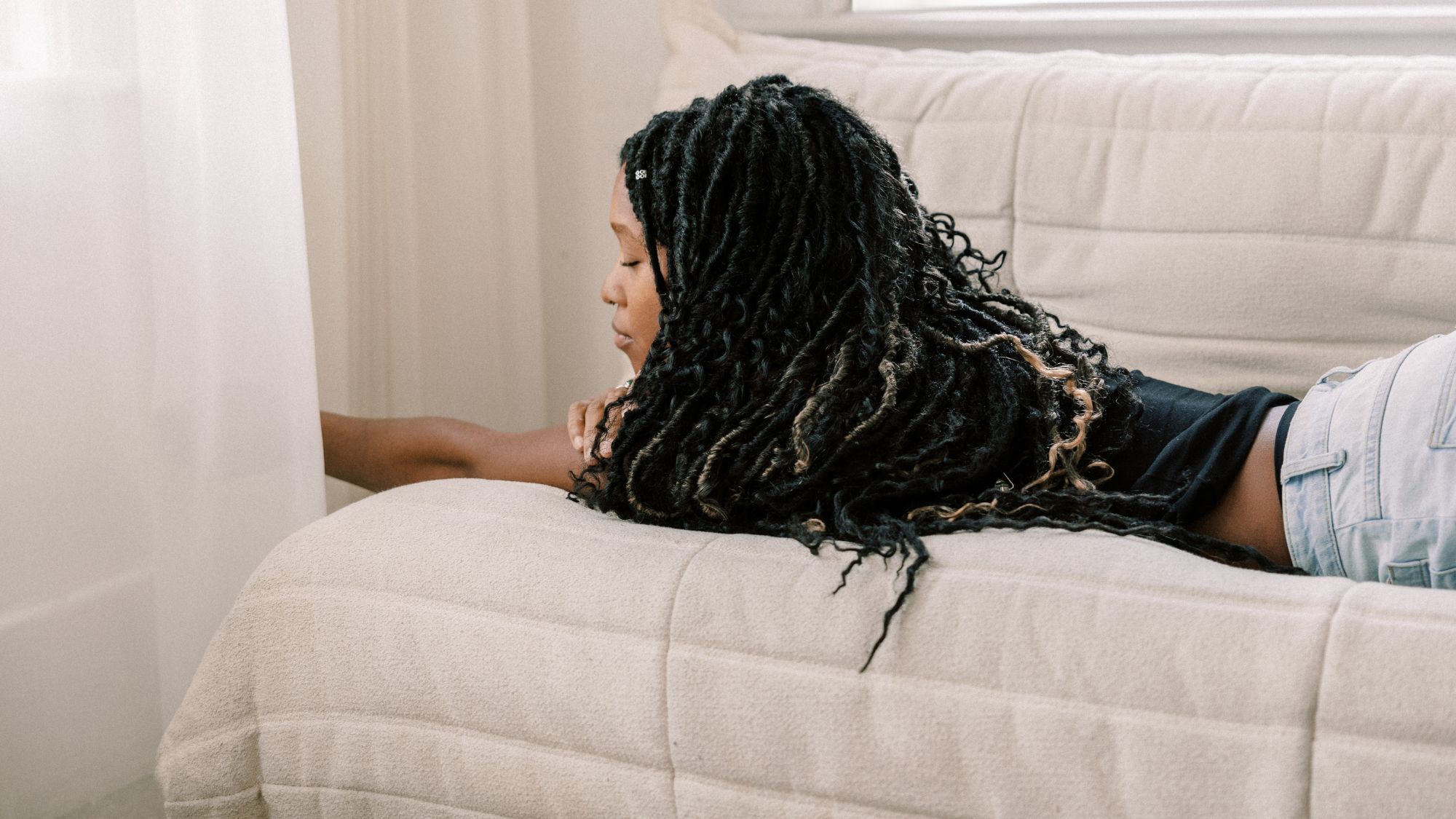 A woman lying on a sofa tired