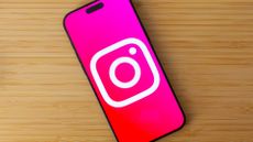 Instagram logo on an iPhone 16 Pro Max on top of a wooden desk