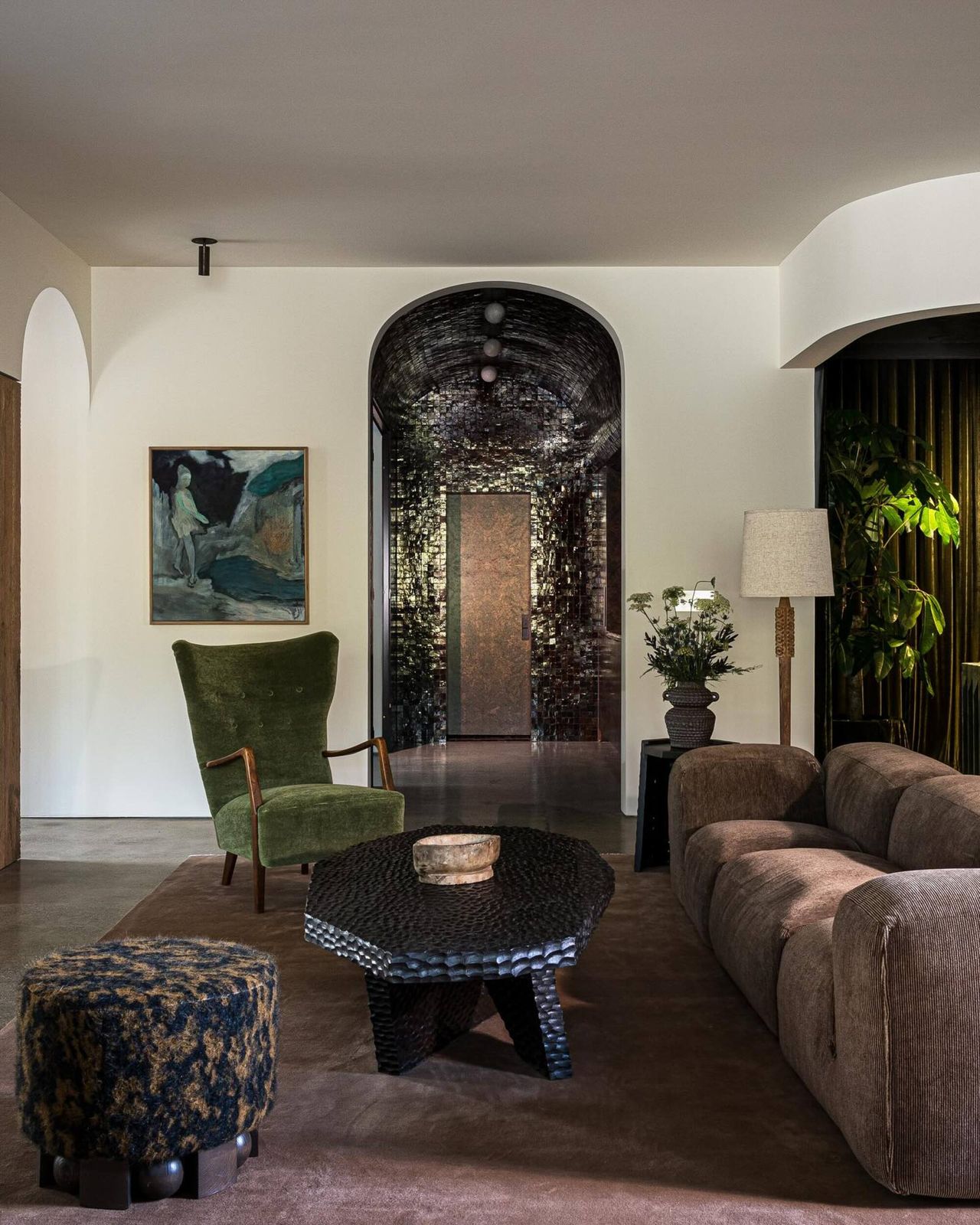 living room with a brown couch, brown rug, dark wood coffee table, and a green accent chair