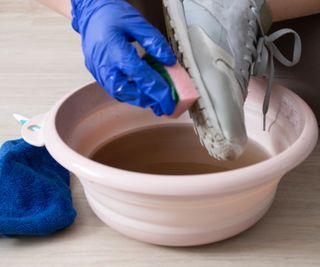 Washing trainers by hand in a bowl