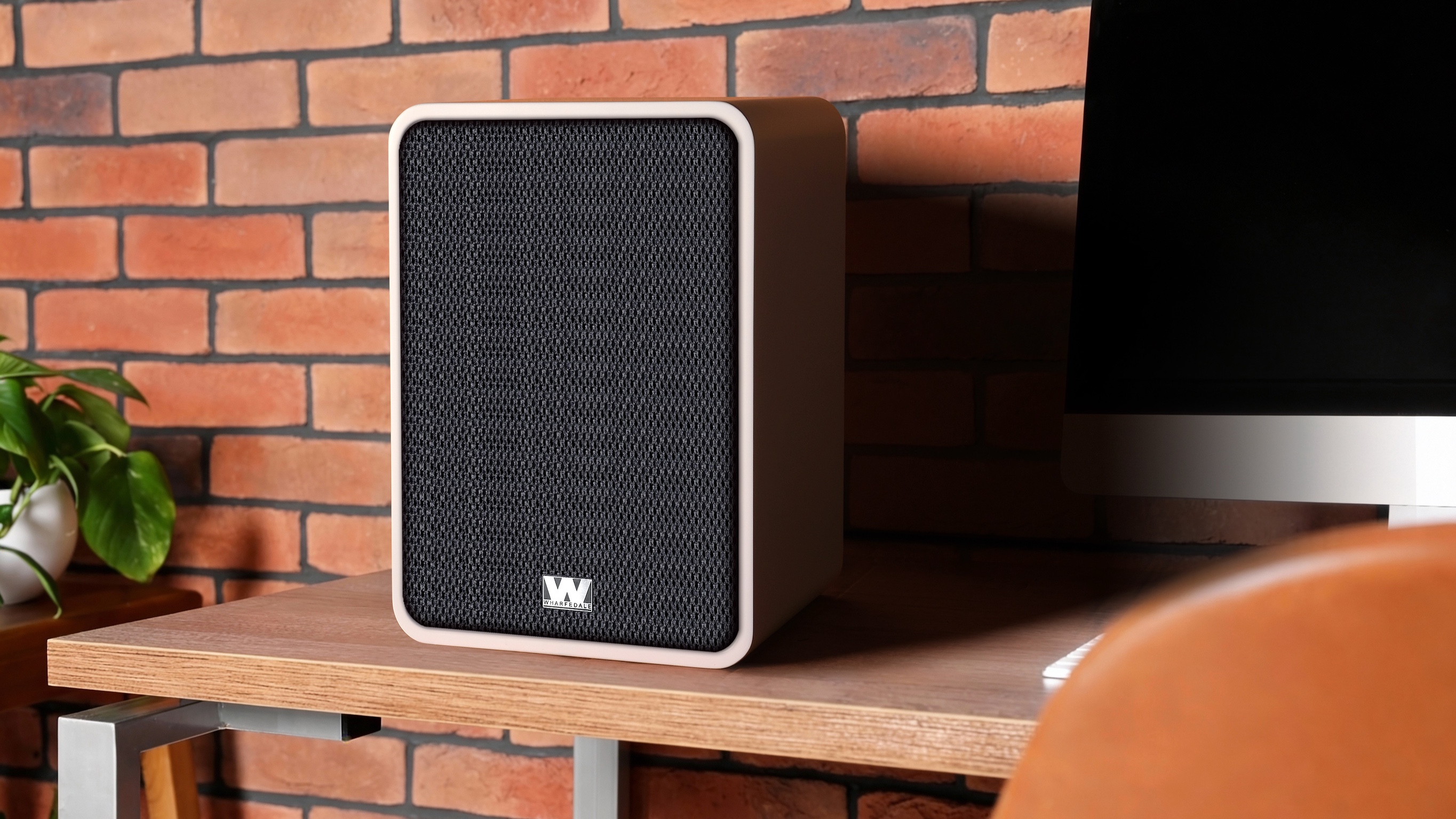 The Wharfedale Denton 1S on a desk next to an iMac computer.