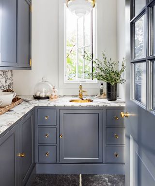 blue kitchen with marble tops and brass accents