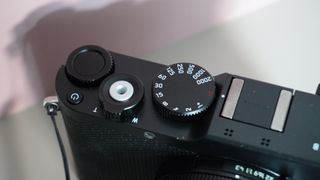 The Leica D-Lux 8 on a grey and pink background