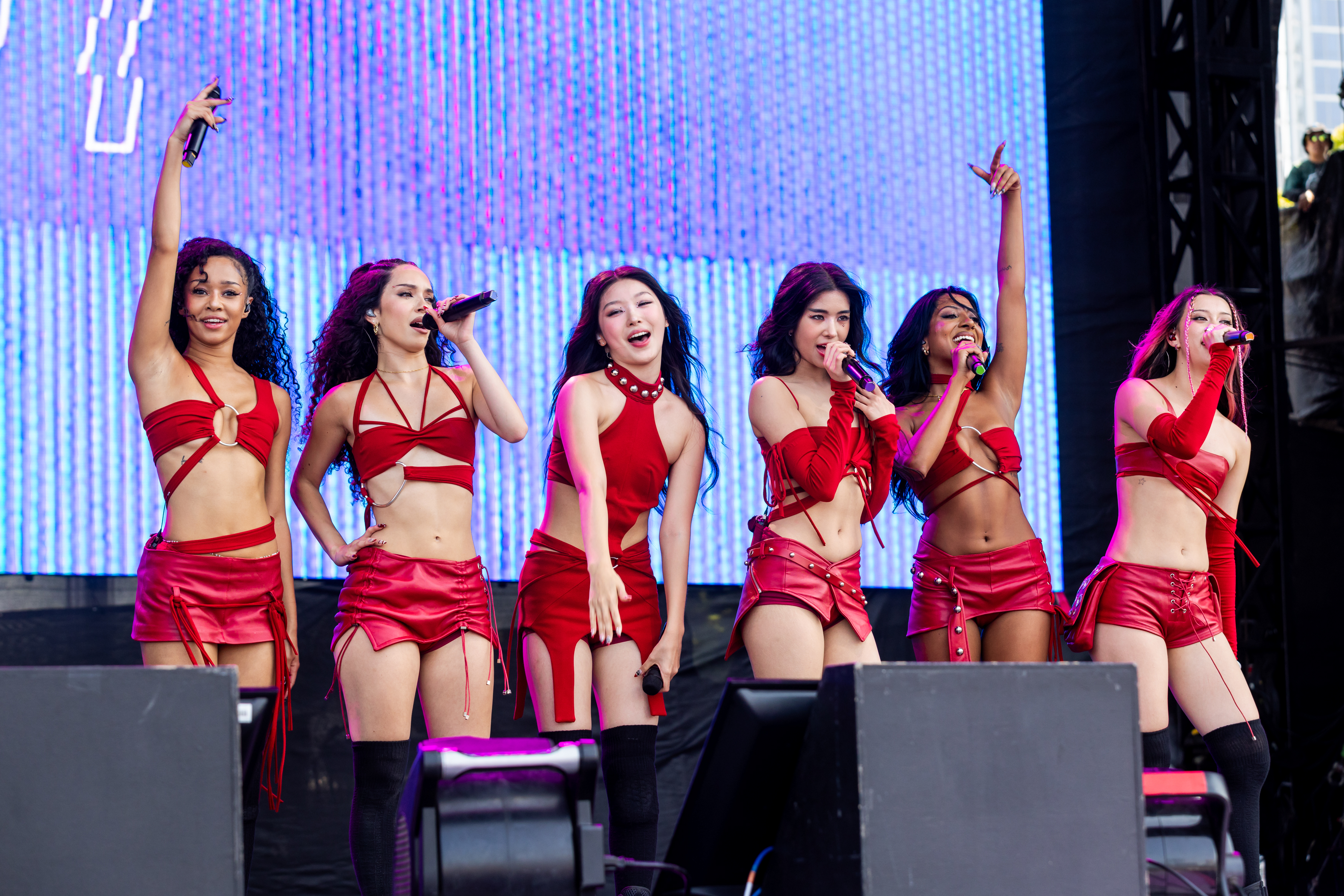 the girl group katseye wears matching red outfits while performing on stage at lollapalooza 2025 in chicago
