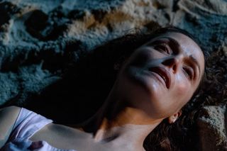 A woman's (Rose Byrne) face is seen as she lies on her back in the sand, in 'If I had Legs I'd Kick You.'