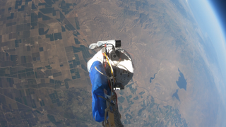 the curve of the earth and black of space is visible in this high altitude balloon photo, along with a piece of hardware flying above distant fields