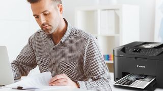 Man Working With Pc And Canon Printer