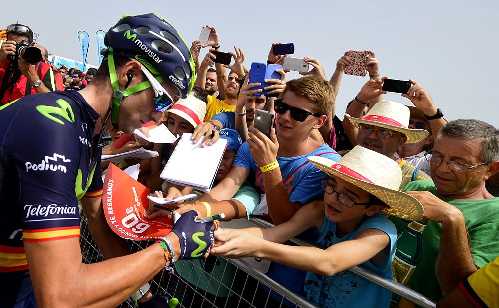 Movistar's Alejandro Valverde signing autographs for fans at the start of stage 10