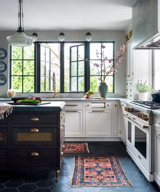 Tudor kitchen with white cabinets, slate hexagon tile flooring and a traditional range cooker