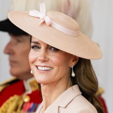 Princess Kate wearing a pink hat with a bow smiling