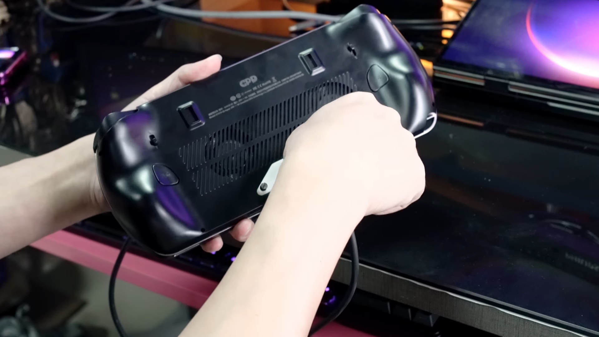 A screenshot of a video from GPD showing off it's new battery optional Strix Halo handheld