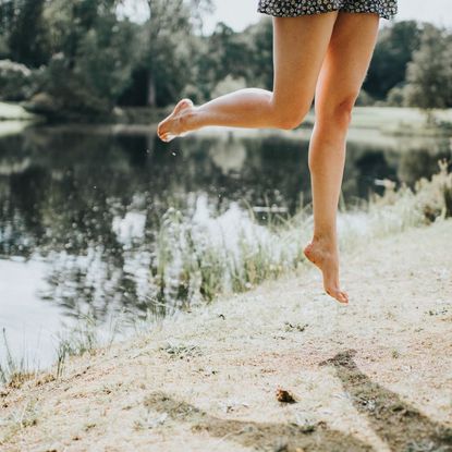 CurrentBody Laser Hair Removal Device - woman jumping in field getty images 1169993276