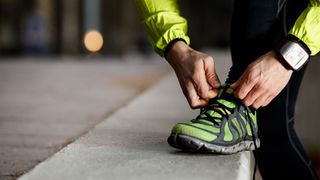 Image of man tying running shoes