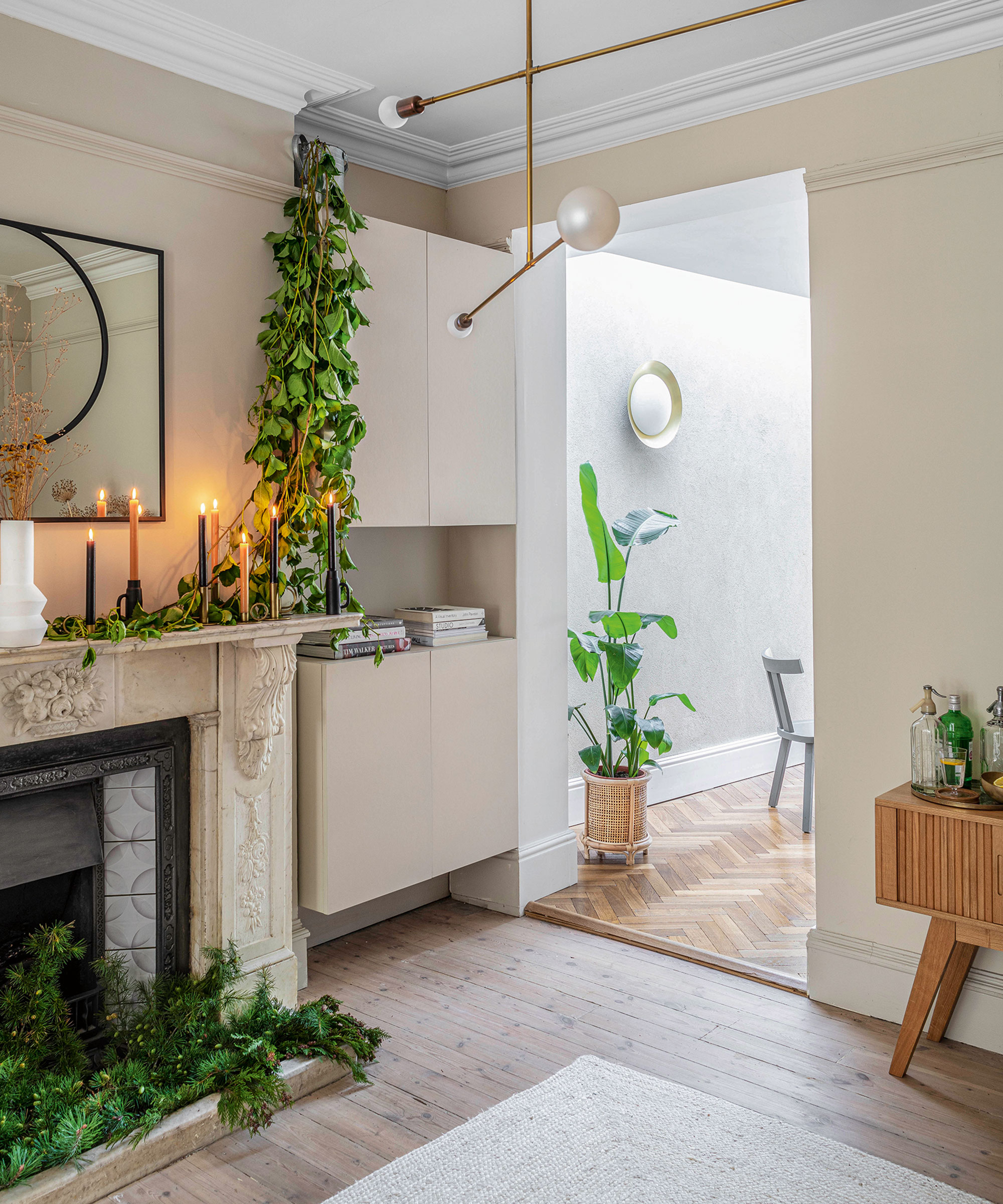 An example of minimalist living room ideas showing a minimalist living room with wall hung storage next to a traditional fireplace