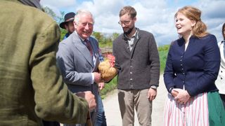 King Charles holding a chicken