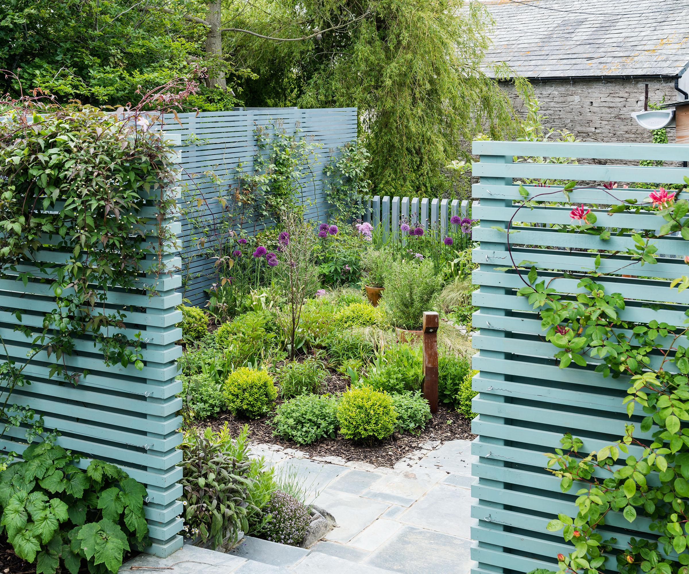 Courtyard garden with wooden slat screen painted in Pigeon from Farrow & Ball