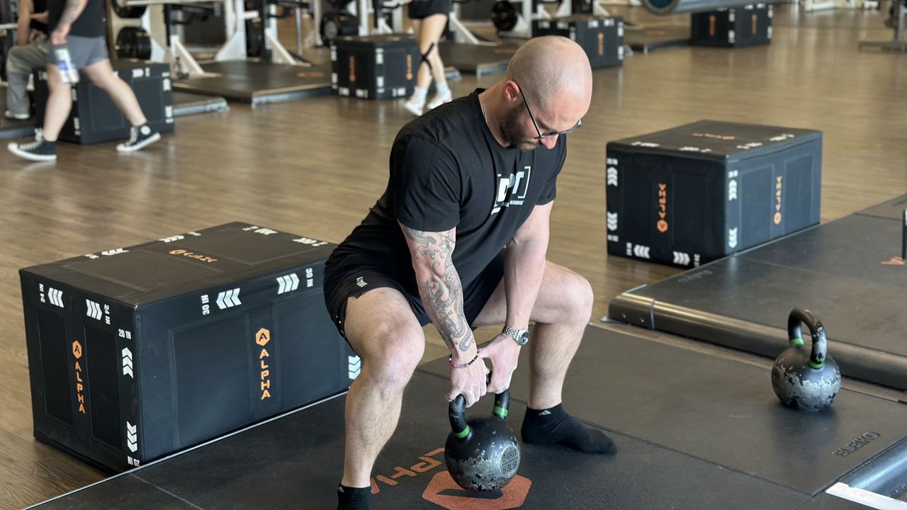 Miller Latvala, personal trainer for Life Time, demonstrates a sumo squat