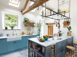 Kitchen with blue cabinets and blue island with hanging utensil rack and open shelves