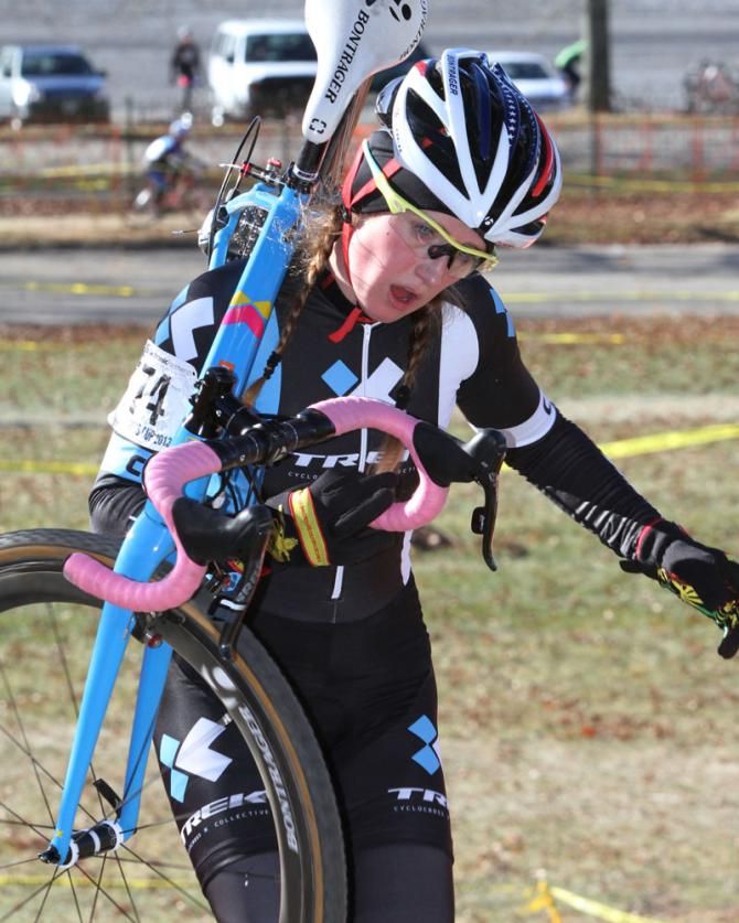 Ellen Noble (Trek Cyclocross Collective) carries her ride through the barriers