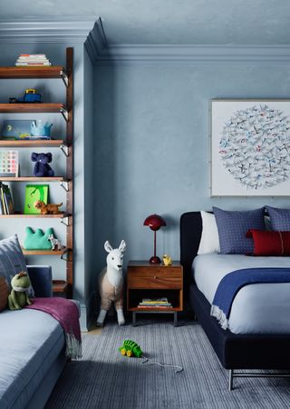A pale blue bedroom with shelving stretching to the ceiling