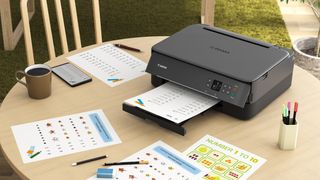 One of the best wireless printers, siting on a table surrounded by printouts