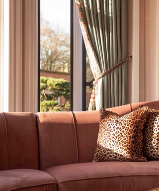 Modern heritage lounge with leopard print cushions on sofa, and curtain tieback rope.