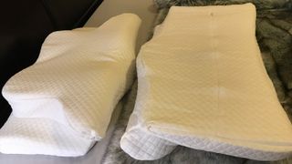 Two Zamat Butterfly Shaped Cervical Memory Foam Pillows on a bed, one upside-down