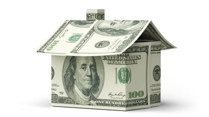 Hundred-dollar bills folded in the shape of a house.