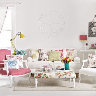 White living room with floral cushions on sofa