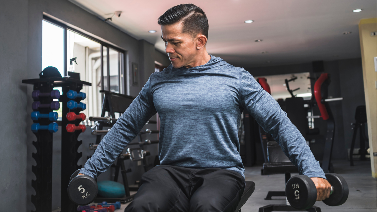 Man performing seated lateral raises at the gym