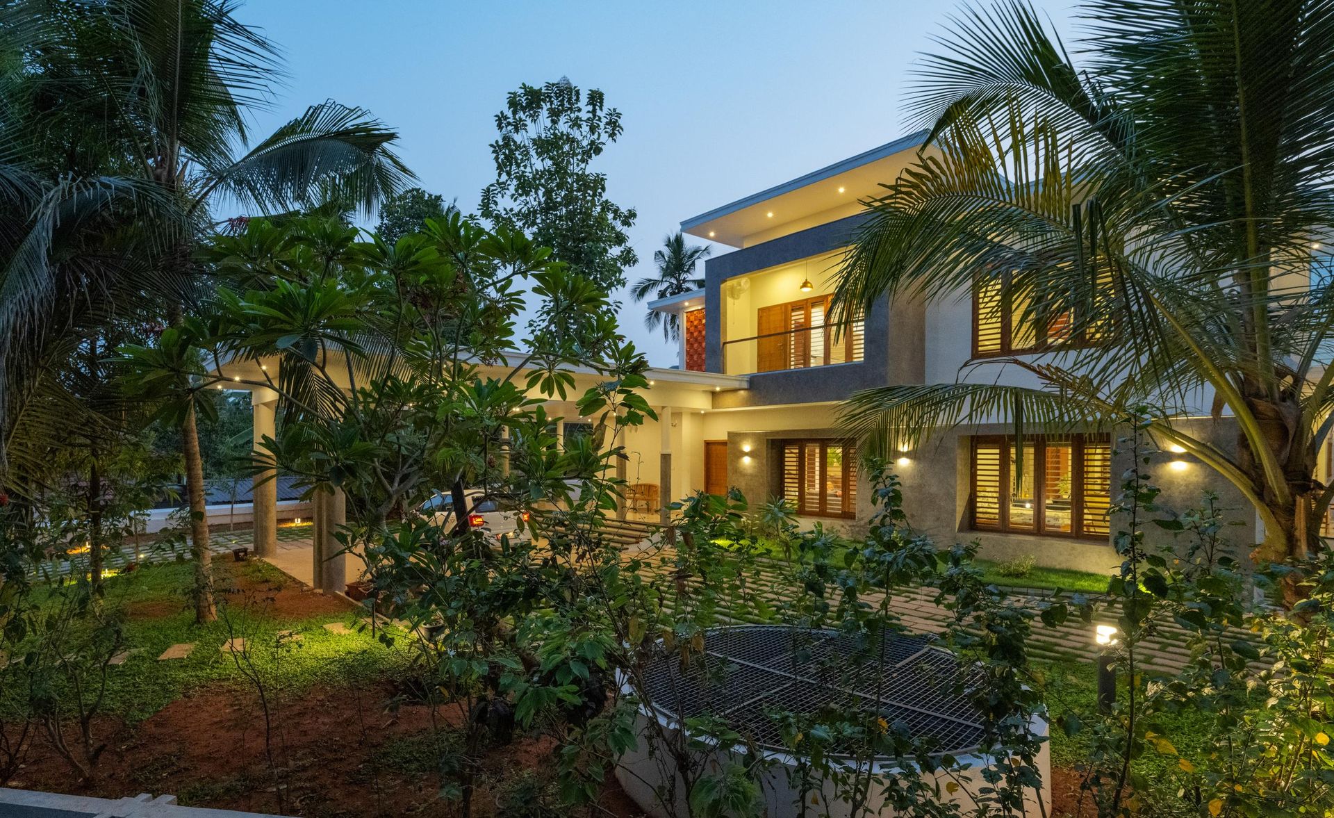 The Manjeri Residence hero exterior at night engulfed in foliage