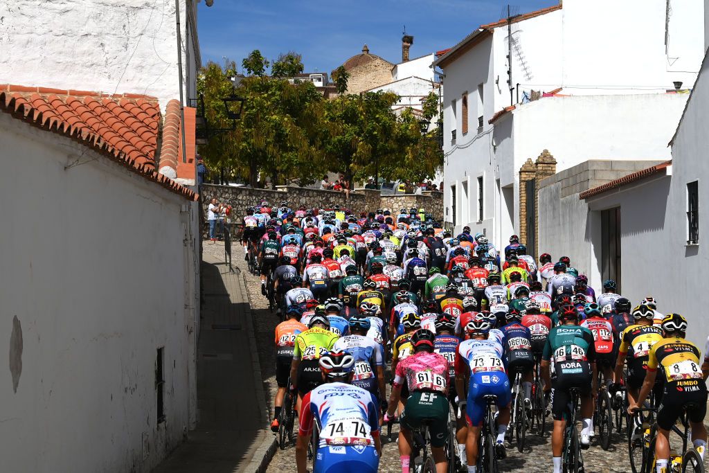 ARACENA SPAIN SEPTEMBER 07 A general view of the peloton passing through Aracena start village while fans cheer during the 77th Tour of Spain 2022 Stage 17 a 1624km stage from Aracena to Monasterio de Tentuda 1095m LaVuelta22 WorldTour on September 07 2022 in Aracena Spain Photo by Tim de WaeleGetty Images