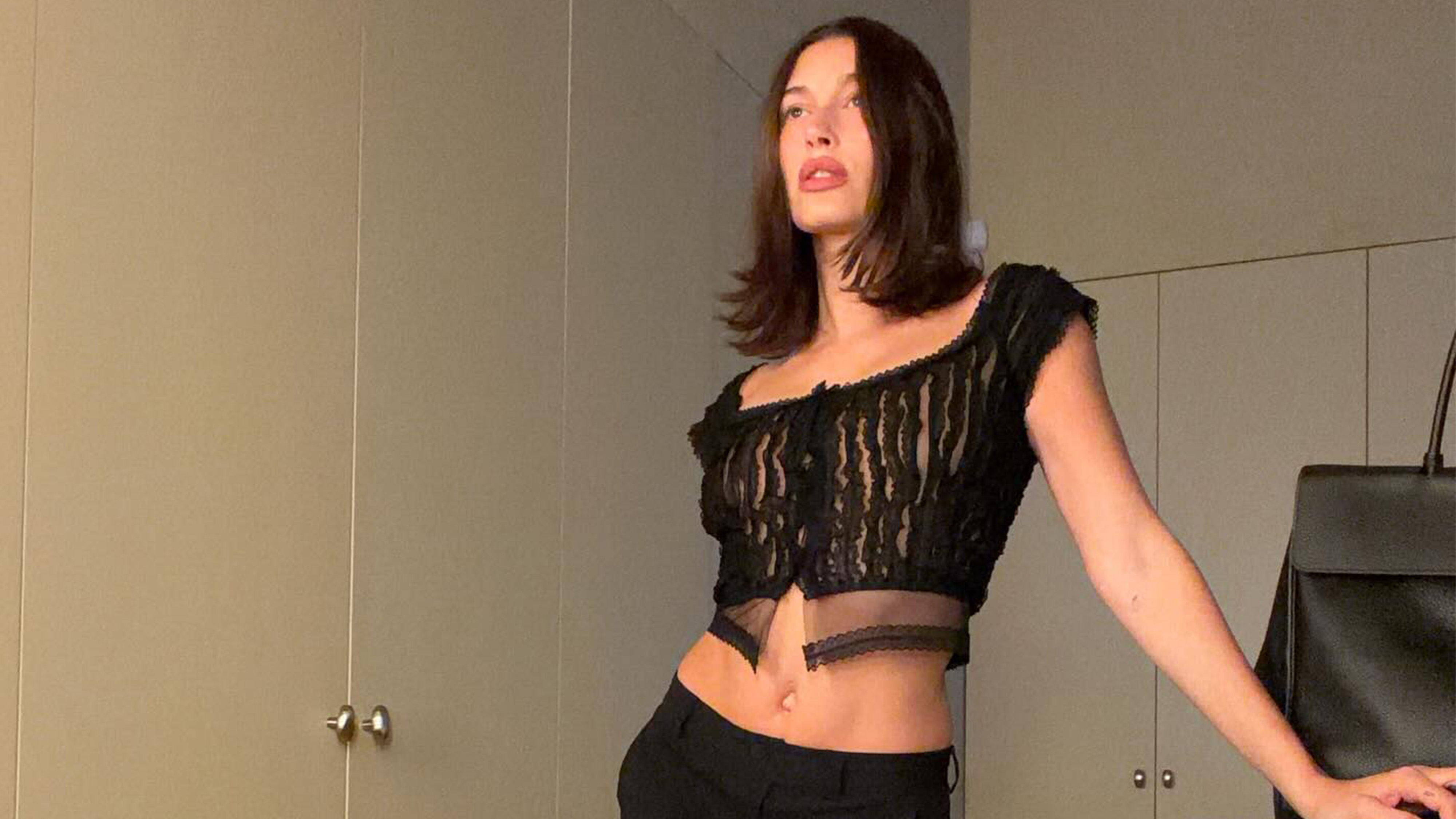 hailey bieber wears a cropped black going-out top.