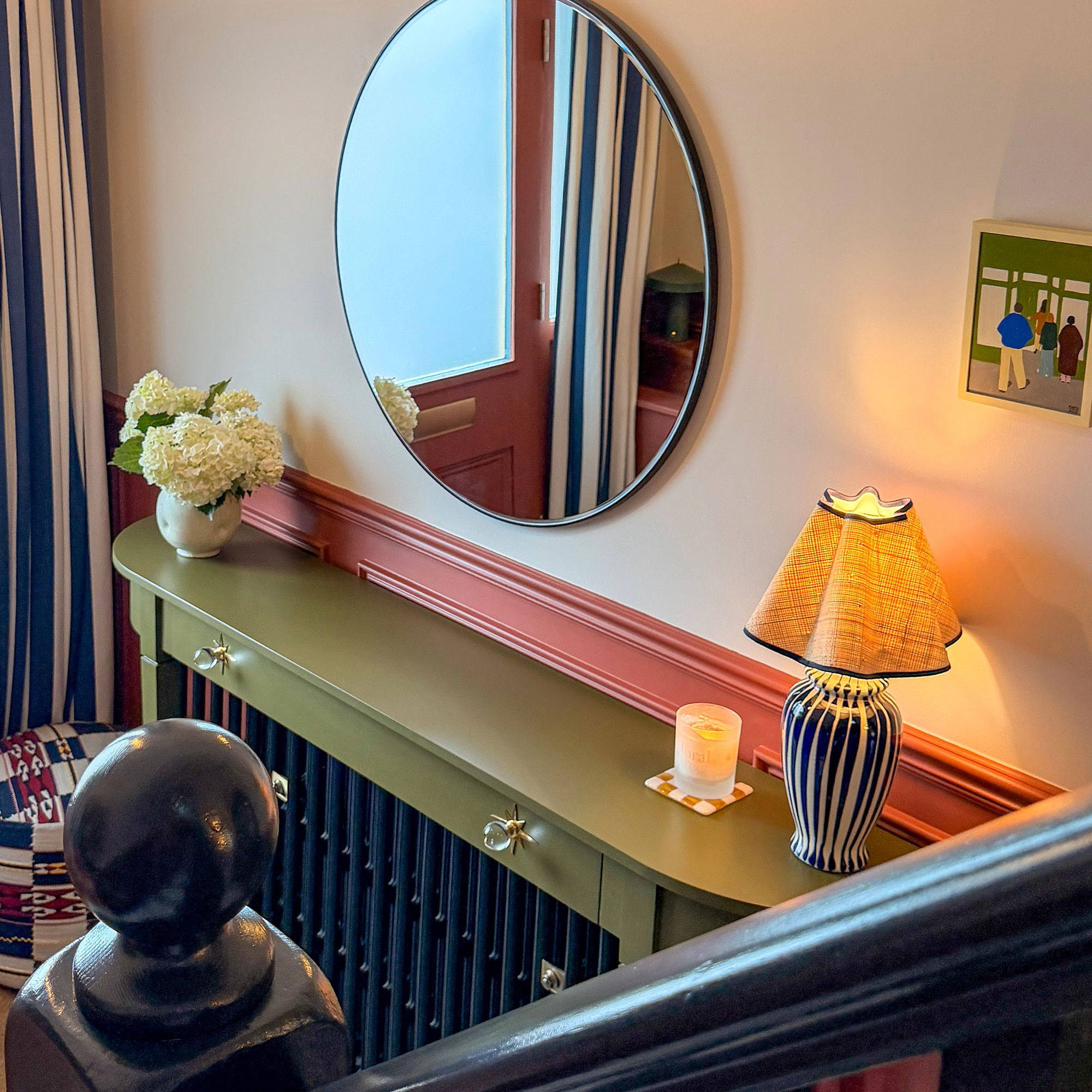 Hallway with green radiator cover with candle and lamp