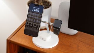 Belkin BoostCharge Pro 3-in-1 Wireless Charger with attached iPhone, AirPods, and Apple Watch on a wooden desk